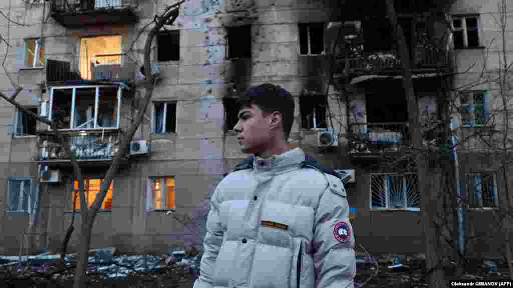 Građanin Odese stoji pored stambene zgrade koja je oštećena u napadu dronom na taj ukrajinski grad.
