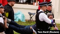 Полиция задерживает активиста Just Stop Oil во время коронации Карла III, май 2023 года
