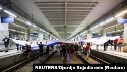 Protestuesit duke mbajtur flamurin serb në binarët e një stacioni hekurudhor në Beograd.