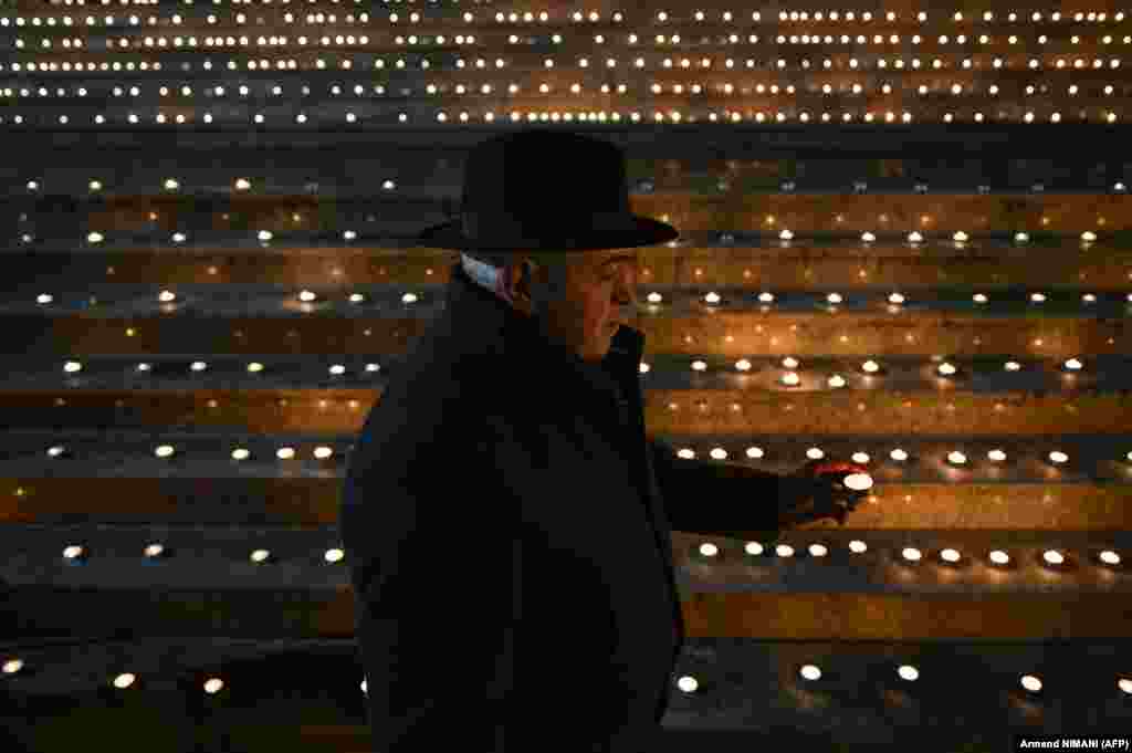 A Kosovar man lights a candle in front of the national theatre in Pristina on January 15 to mark the 25th anniversary of the Racak Massacre. In 1999, 45 Albanian civilians were killed by Serb forces in the village of Racak. The massacre, one of the bloodiest that occurred in the Kosovo crisis, led to a NATO-led air campaign that ousted Serbian security forces from Kosovo.