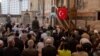 Vjernik drži tursku zastavu tokom molitve u muzeju Hora ili džamiji Karije u Istanbulu, Turska, 6. 5. 2024.
