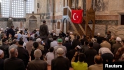 Vjernik drži tursku zastavu tokom molitve u muzeju Hora ili džamiji Karije u Istanbulu, Turska, 6. 5. 2024.