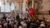 Верник држи турско знаме за време на молитвата во музејот Хора или џамијата Карија во Истанбул, Турција