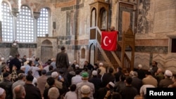 Верник држи турско знаме за време на молитвата во музејот Хора или џамијата Карија во Истанбул, Турција