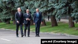 Președinții țărilor baltice - Gitanas Nausėda din Lituania (stânga), Alar Karis din Estonia și Edgars Rinkēvičs din Letonia - plimbându-se pe lângă un rând de pini din apropierea Casei Guvernului de la Chișinău, pe 27 august 2024