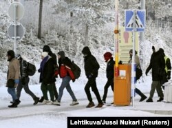 Беженцы с российской территории идут по международному пограничному переходу в Салле, северная Финляндия, 22 ноября 2023 года