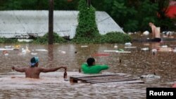 Ljudi u poplavljenom području pored rijeke Taquari tokom jakih kiša u Encantadu, država Rio Grande do Sul, Brazil, 2. maja 2024.