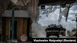 Ukrainian military vehicles pass a crossing point at the border with Russia in the Sumy region on August 13.