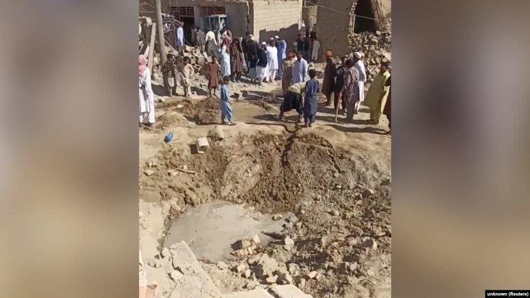People gather near rubble in the aftermath of Pakistan's military strike on an Iranian village in Sistan-Baluchistan Province on January 18.