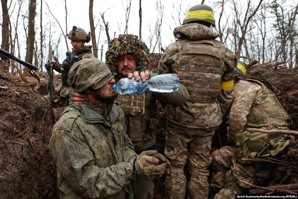 Një ushtari rus i jepet ujë pas kapjes së tij nga forcat ukrainase pranë Bahmutit në majin e vitit 2023. 