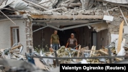 Local men stand stand inside a residential building heavily damaged during a Russian missile strike in the village of Rozhivka in the Kyiv region, Ukraine, on August 11.