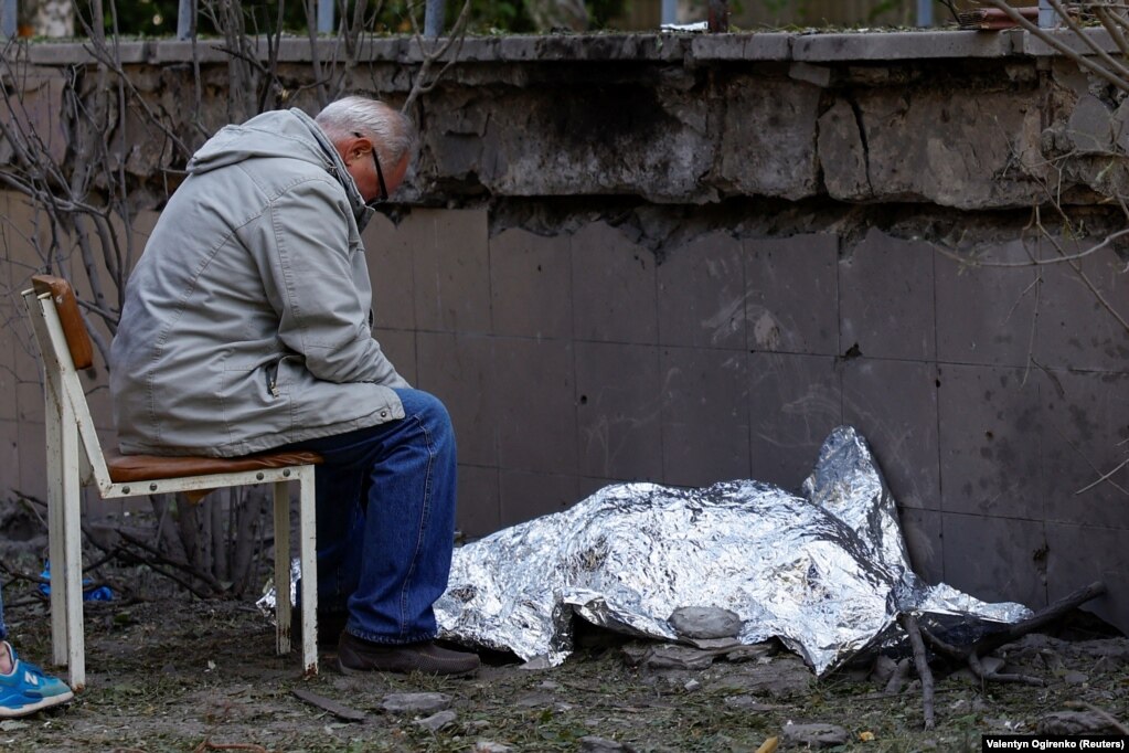 Un bunic stă lângă cadavrul nepoatei sale, ucisă în timpul atacului cu rachete.