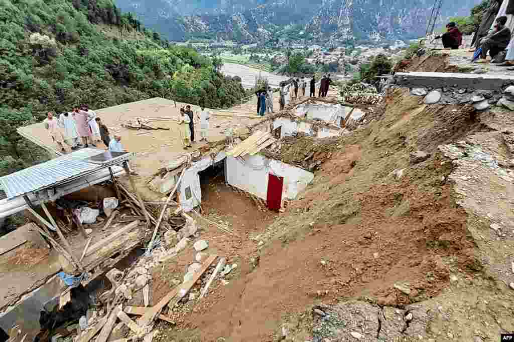 Residents gather at the site of a landslide in the remote area of Patrak in the Upper Dir district of Pakistan&#39;s Khyber Pakhtunkhwa Province on August 30. Twelve people died on August 30 when a landslide triggered by heavy rains destroyed their house, rescue officials said, with more than 300 killed since the start of the monsoon season.