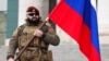 Чеченский военнослужащий с российским флагом. Грозный, 4 января 2024 года