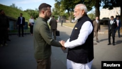 Indian Prime Minister Narendra Modi (right) and Ukrainian President Volodymyr Zelenskiy shake hands before visiting a memorial to children killed during Russia's attack on Ukraine, in Kyiv on August 23. 