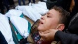 Хан-Юнистеги бомбалоодон каза тапкан жакындарынын сөөктөрүнүн жанында турган палестиналык бала. Газа, 10-декабрь, 2023-жыл