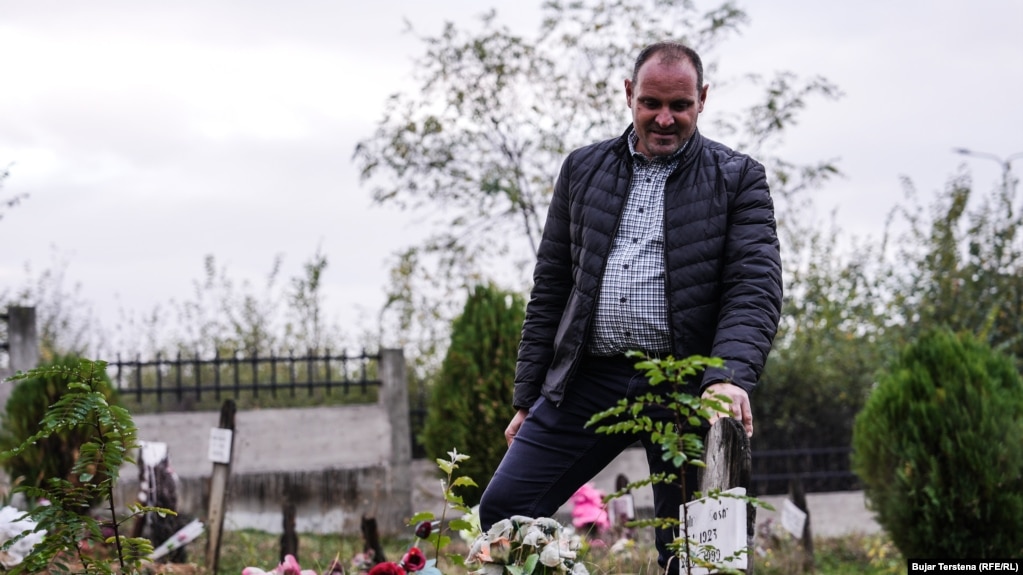 Arben Gashi pranë varreve të familjarëve të vrarë gjatë sulmit të forcave serbe më 26 mars 1999 në Landovicë.