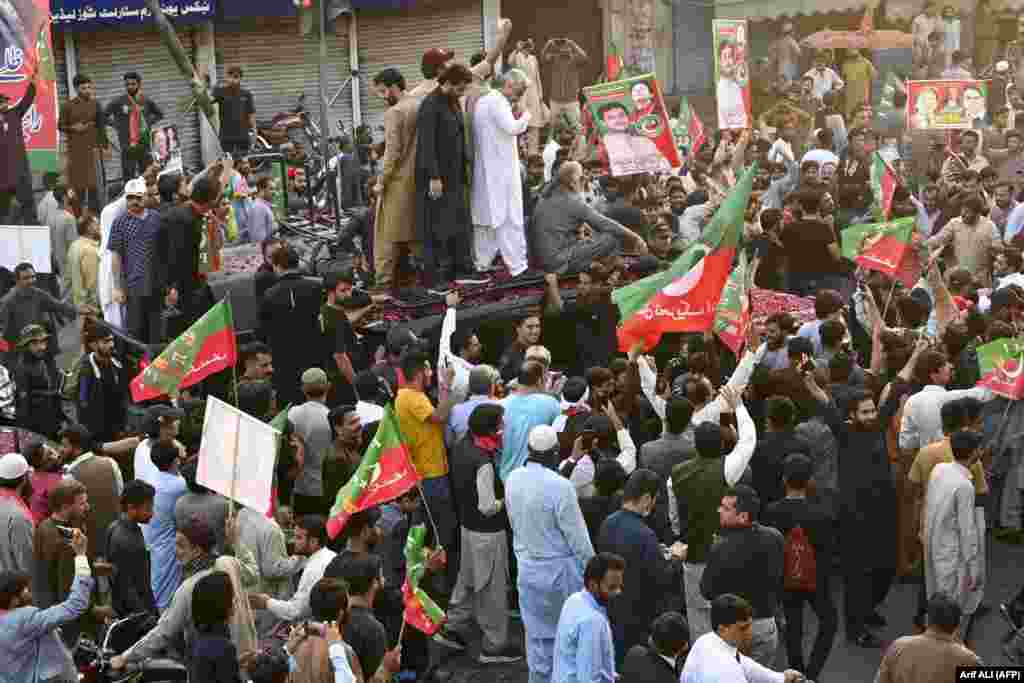 Security personnel and supporters escort a vehicle carrying former Pakistani Prime Minister Imran Khan in Lahore during an election campaign rally for Punjab&#39;s provincial assembly to be held next month.&nbsp;