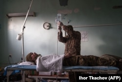 Український військовий медик надає допомогу пораненому солдатові неподалік лінії фронту в Донецькій області
