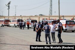 Zdravstveni radnici čekaju ranjene Palestince na prelazu Rafa kako bi ih odveli u bolnicu u Egiptu, 1. oktobar 2023.