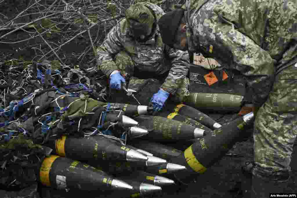 Ukrainian soldiers prepare artillery shells.