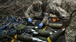 Ushtarët ukrainas përgatiten të qëllojnë mbi pozicionet ruse me një obus artilerie 155 mm M777 në vijën e frontit diku afër qytetit të Bahmutit më 11 mars 2023, në mes të pushtimit rus të Ukrainës.