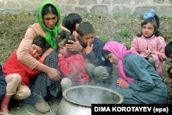 An ethnic Azeri woman displaced by the conflict in Nagorno-Karabakh comforts her children in Adjikend, Azerbaijan, in April 1993.