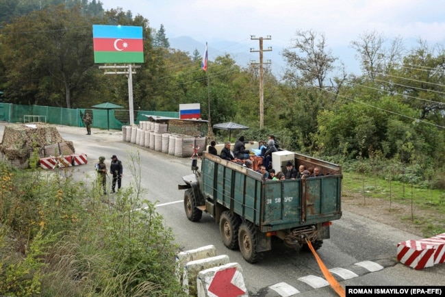 Ethnic Armenians flee Nagorno-Karabakh for Armenia in a truck at the Lachin checkpoint controlled by Russian peacekeepers and Azerbaijani border guards in September 2023.