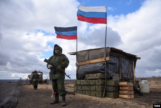 La polizia della Repubblica popolare di Donetsk presidia un posto di blocco nel territorio ucraino occupato dai russi il 27 marzo 2022.