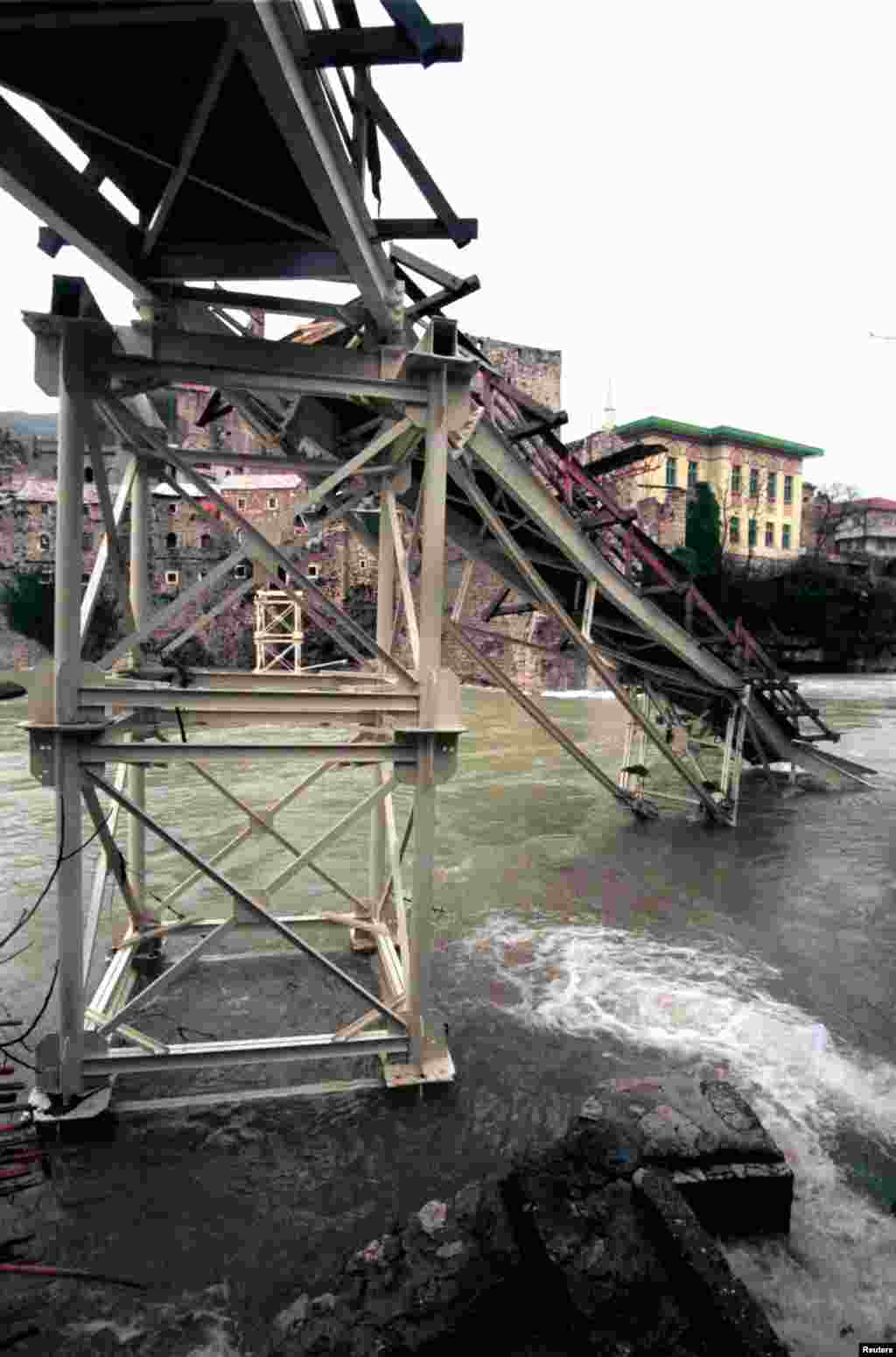 This footbridge was destroyed by flooding in December 1999. Calls for rebuilding the iconic stone bridge using the same materials as the original were led by Mostar architect Amir Pasic. In 1993, Pasic, who was living abroad at the time, began handing out &quot;invitations&quot; to the bridge&rsquo;s reopening in 2004 -- 11 years into the future. He later recalled people &quot;were laughing&quot; at the distant and ambitious goal as the Bosnian War was still ongoing.