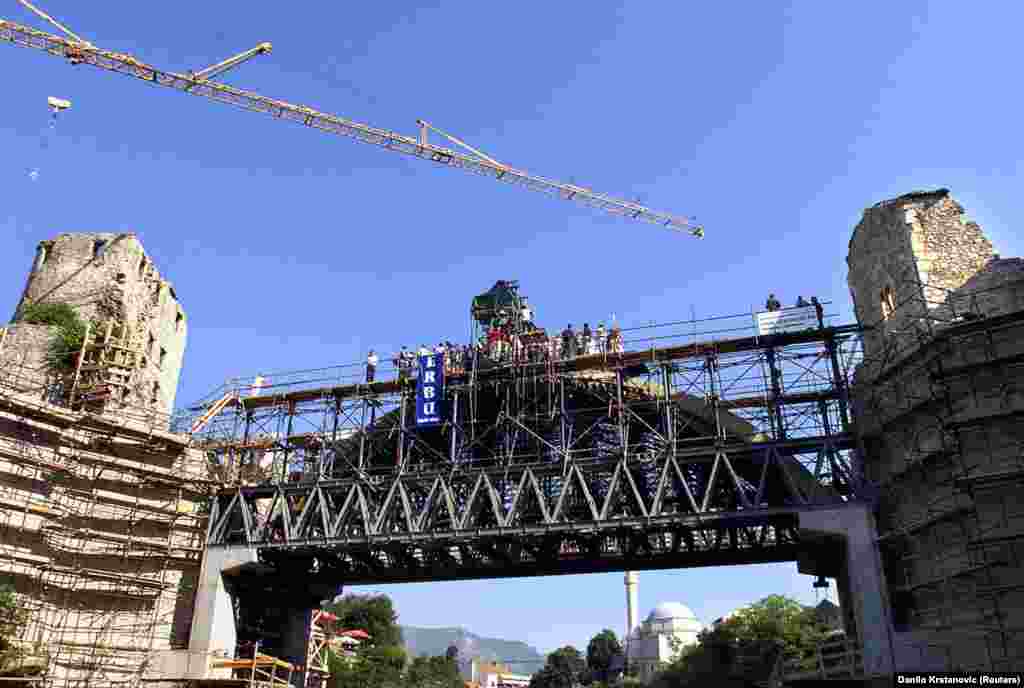 Stones are laid across the arch of the bridge&#39;s replacement in August 2003. By 1998, the project to restore the bridge and its surroundings was officially launched with funding from Croatia, France, Italy, the Netherlands, and Turkey. &nbsp;