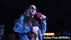  Хентри приказва на микфрофон, до момента в който държи на рамо шампионския си пояс. Той приказва против тълпата по време на кеч събитие в Киев. 