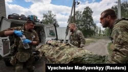 Военные медики оказывают помощь раненому украинскому военнослужащему во время нападения России на Украину вблизи города Волчанск Харьковской области, Украина, 12 мая 2024 года
