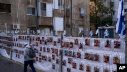 Фотографии на некои од заложниците на Хамас на ѕидот во Тел Авив, 21 ноември 2023 година