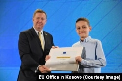 Ledion Halitaj duke pranuar çmimin "Evropiani i Vitit" nga ambasadori i BE-së në Kosovë, Tomas Szunyog.