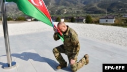 Authoritarian Azerbaijani leader Ilham Aliyev kneels after raising his country's flag in the former breakaway region of Nagorno-Karabakh on October 15. 