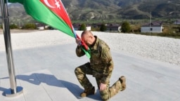Authoritarian Azerbaijani leader Ilham Aliyev kneels after raising his country's flag in the former breakaway region of Nagorno-Karabakh on October 15. 