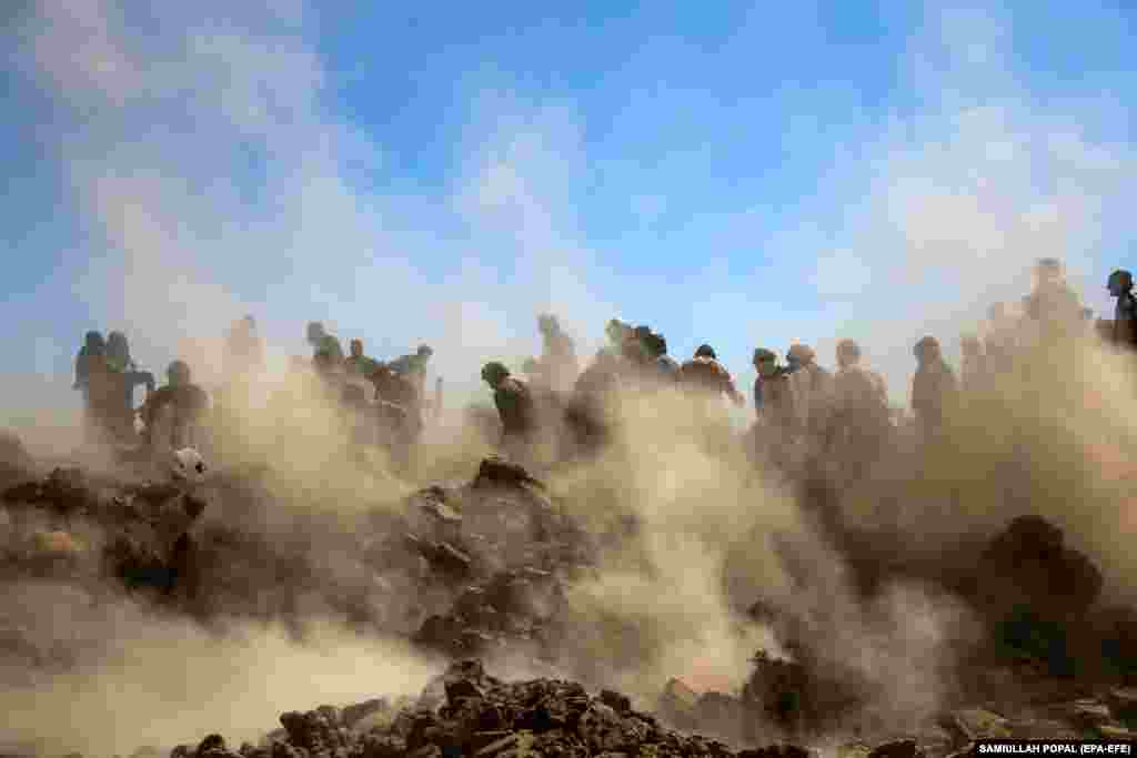 People search for victims amid the rubble of destroyed houses following an earthquake in the Zindah Jan district of Herat Province, Afghanistan.