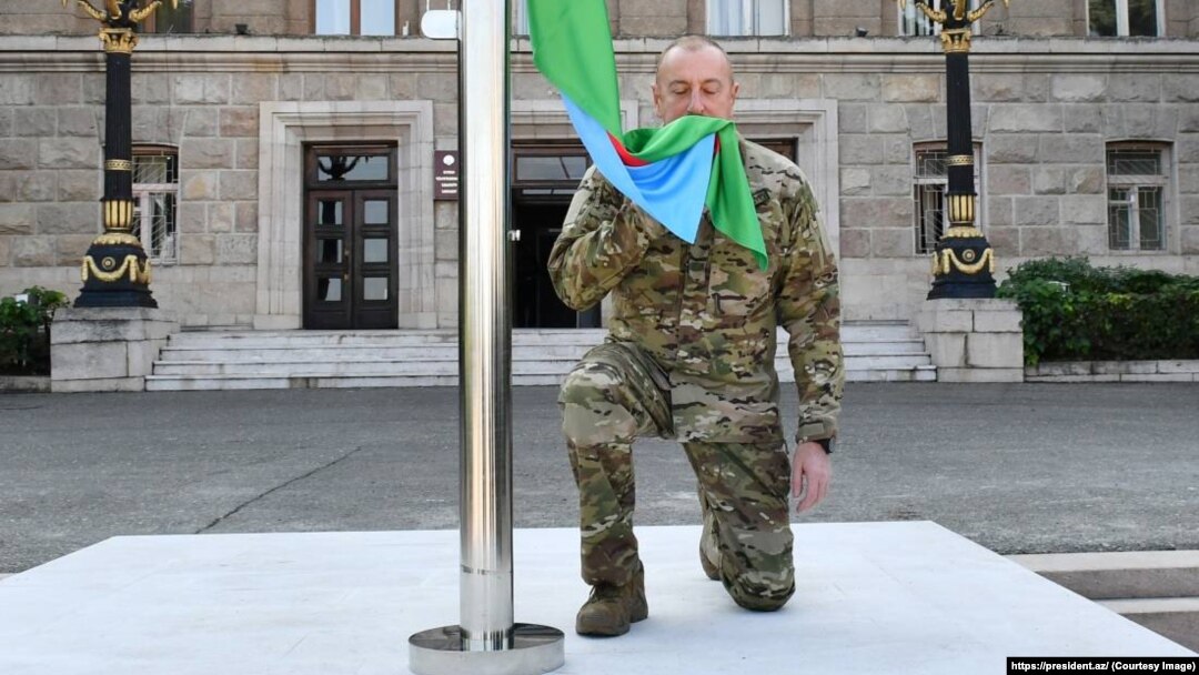 Azerbaijani President Ilham Aliyev raises the national flag of in Xankendi on October 15.