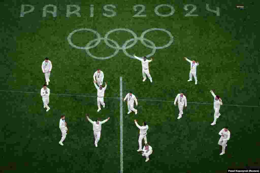 Medalistët e artë të ekipit të Francës vallëzojnë në fushë ndërsa festojnë pas ceremonisë së marrjes së medaljeve.