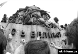 Тодішня площа Жовтневої революції (нині майдан Незалежності) у столиці України. Люди відбивають літери на монументі, присвяченому більшовицькому «жовтневому перевороту», центральною частиною якого була скульптура Леніну. Київ, вересень 1991 року