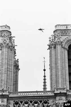  Снимка от юни 1971 година на Филип Пети, който е лежащ върху въжето сред камбанариите на Нотр Дам в Париж. 