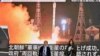 Ljuid prolaze pokraj ekrana koji prikazuje lansiranje sjevernokorejskog izviđačkog satelita 'Malligyong-1', u četvrti Akihabara u Tokiju 22. novembra 2023.