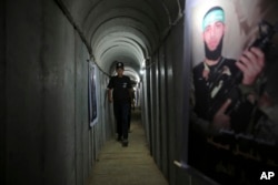 На тази снимка от 2016 г. палестинец върви в тунел, използван за военни упражнения по време на изложба на оръжия в младежки летен лагер, управляван от Хамас, в град Газа.
