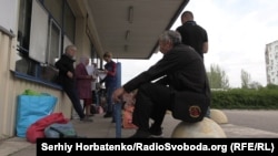 People wait for the Proliska bus in the Donest region village of Illinivka.