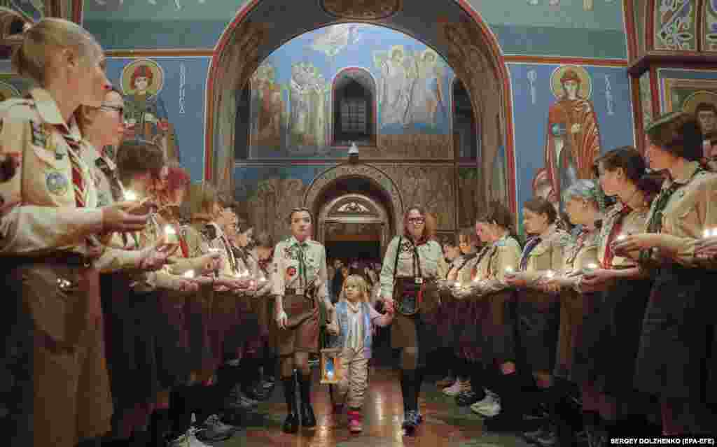 A December 2022 file photo of the peace flame arriving at St. Michael&#39;s Cathedral in Kyiv, past rows of girl scouts.&nbsp; The stated aim of the flame&#39;s distribution is to &quot;bring the message of light and peace to as many people as possible.&quot; Several European countries have begun receiving the flame in recent years.&nbsp;&nbsp; &nbsp;