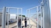 Rendőrök hajtják be a röszkei tranzitzóna kapuját 2017. június 18-án