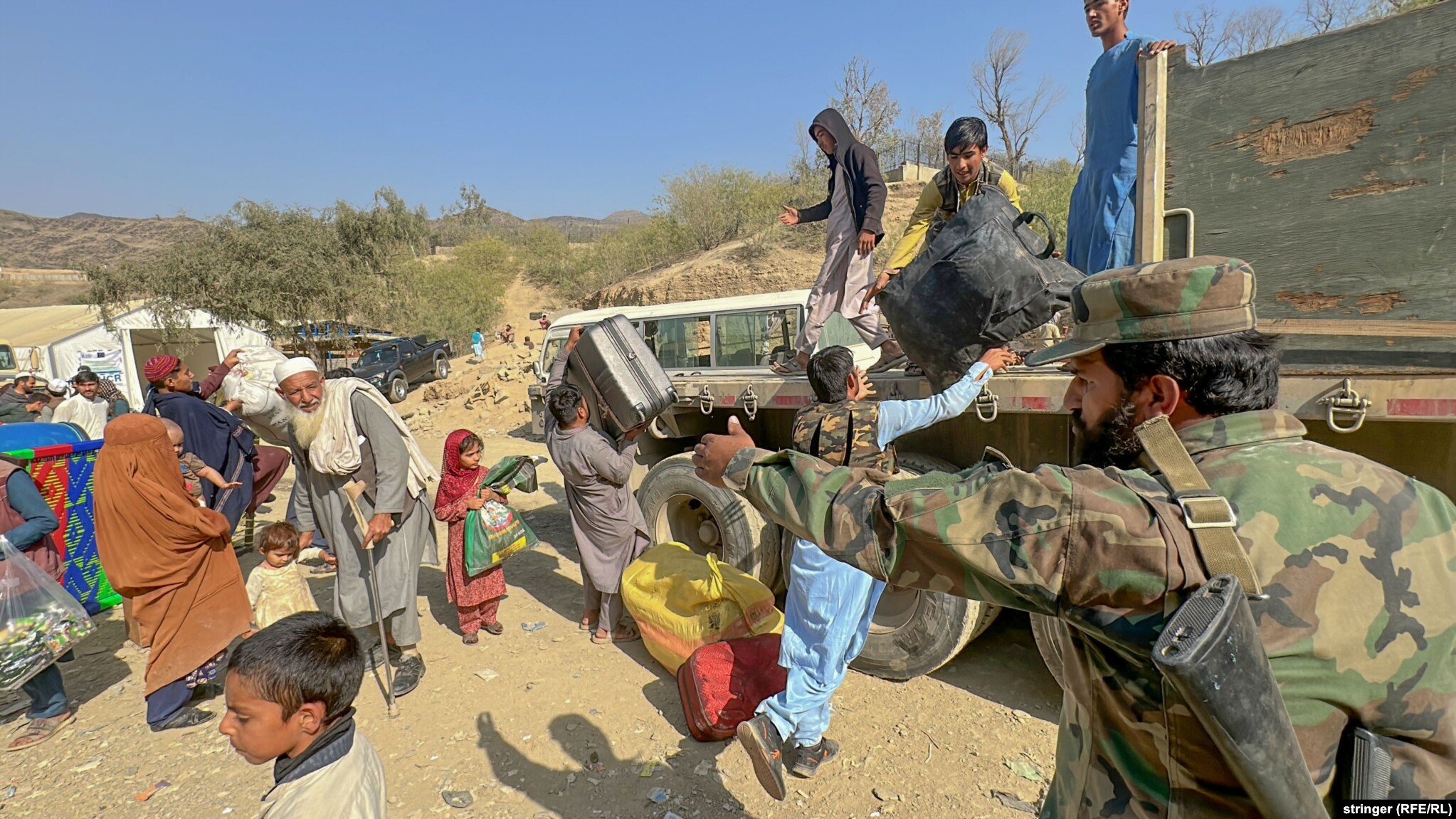 Taliban security personnel direct Afghan returnees after they crossed over into Afghanistan near the Torkham border crossing with Pakistan on November 5. An estimated 300,000 Afghans have fled Pakistan in recent weeks following Islamabad&#39;s order that 1.7 million undocumented refugees and migrants leave the South Asian country or face arrest or expulsion.