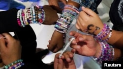 Тийнейджъри си разменят гривни за приятелство преди началото на концерт от Eras Tour в Мексико Сити, Мексико, 13 октомври 2023 г.