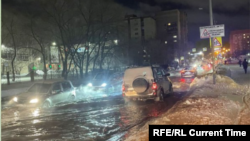 Vehicles struggle to drive through the flooded streets of Novosibirsk on January 11.
